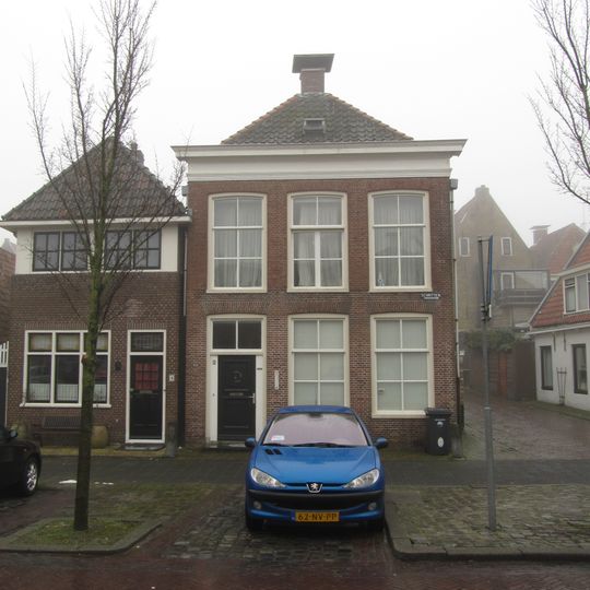 Hoekpand met opkamer op beganegrond en rechte kroonlijst onder schilddak met voorschild en topschoorsteen