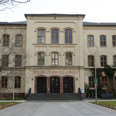 Einzeldenkmal der o. g. Sachgesamtheit: zur Hochschule gehörender Gebäudekomplex, bestehend aus zwei historischen Schulgebäuden (der ehemaligen Bürgerschule, später Stadthaus I und dem Gymnasium, heute Georgius-Agricola-Bau) sowie dem hofseitig
