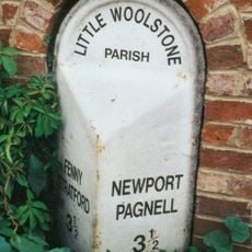 Milepost, Newport Road; Woolstone at jct with Cleobury Paddock, next to Cleobury Farm (in a housing estate)