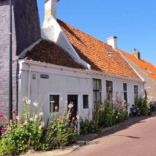 Laag pandje onder dwarskap tussen geveltoppen, bekroond door schoorsteen met dekplaat