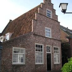 Pand onder zadeldak tegen gepleisterde trapgevel