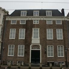 Pand met eenvoudige bakstenen gevel met kroonlijst op gesneden consoles, hoekpilasters, versierde middentravee, met poort, die toegang geeft tot de Portugees-Israelitische synagoge