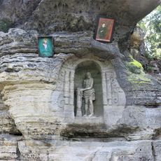 Skalní reliéf bičovaného Krista u lesní cesty severovýchodně od Radvance