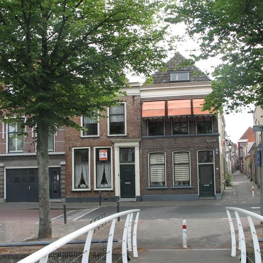 Pand met lijstgevel, eenvoudige voordeuromlijsting, muurankers en dakkapel