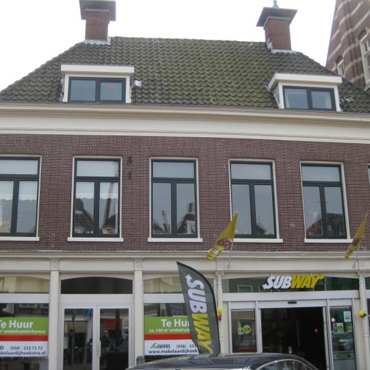 Zes traveeën breed pand onder dwars schilddak met twee hoekschoorstenen met borden