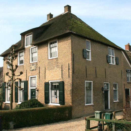 Gedeelte van een boerderij, in oorsprong tevens rechthuis, met verdieping onder rieten schilddak. Op de verdieping een kruiskozijn met luiken. Vormt een geheel met het buurnummer 11-14