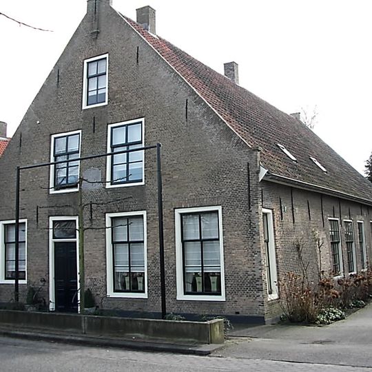 Bakstenen woonhuis met schoolruimte ondergebracht in het achterhui