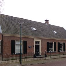 Boerderij, langgerekte gepleisterde gevel, met zadeldak