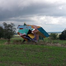 Abstrakte geometrische Skulptur auf einem Feld