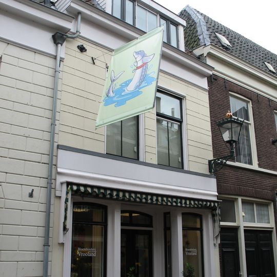 Pand met gepleisterde lijstgevel en met restanten van de middeleeuwse stadsmuur
