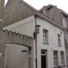 Huis met eenvoudige witte lijstgevel en sierankers