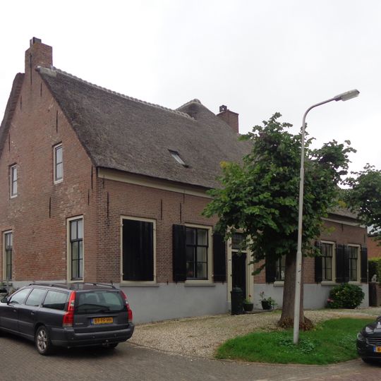 Boerderij, breed woonhuis, rechts onderkelderd, met rieten zadeldak, waarin een dakkapel, waaronder een strolaag