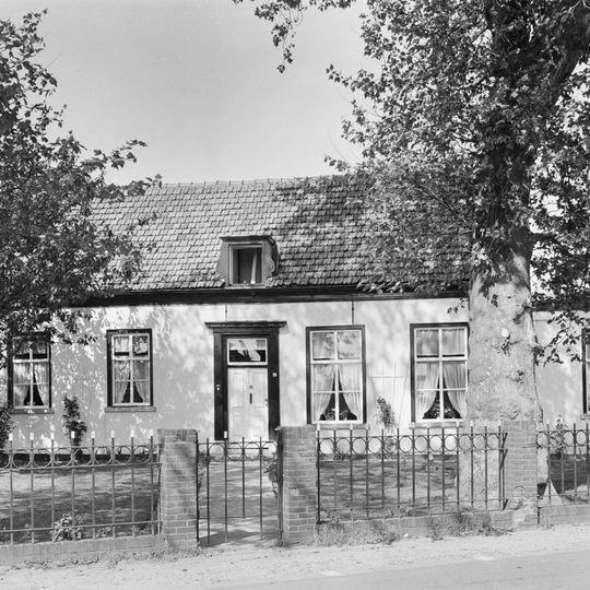 Dwarshuis onder zadeldak; zesdelige Empire schuiframen, omlijste ingang, gepleisterde gevel