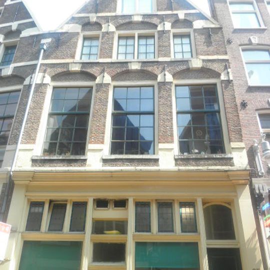 Pand met tot puntgevel afgekloofde trapgevel met grote boogblokken als versiering