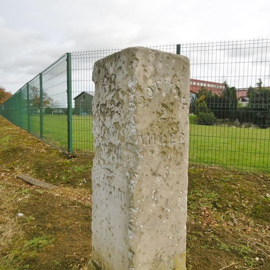 Milestone, Biggleswade Road, in front of school car park entrance