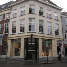 Huis met gebosseerd gepleisterde lijstgevel op de hoek van de lievevrouwestraat